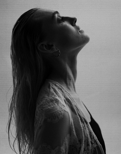 A woman is posing in sideways. The picture is monochrome.